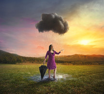 a woman with an umbrella standing under a rain cloud 