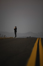 a man praying in the middle of a road 