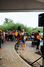 musicians singing at an outdoor worship service 