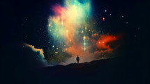 Silhouette of a man standing on the top of a mountain and looking at the colorful nebula