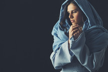 Mary in a blue shroud with praying hands 