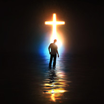 A man standing before a glowing cross.