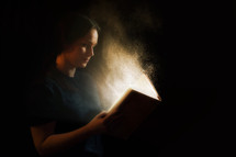 Woman reading an illuminated Bible.