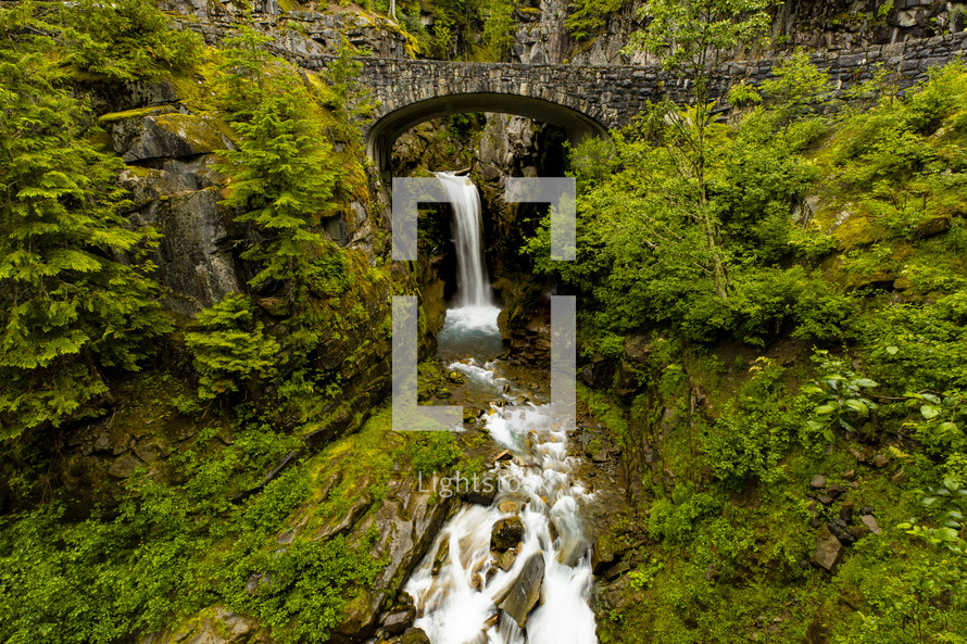 stone bridge on a mountain over a waterfall 
