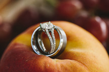 wedding band and engagement ring lying on a peach