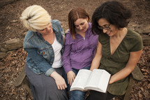 three woman reading a Bible together 