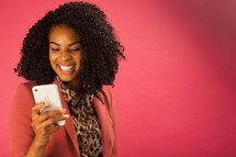 woman looking at a cellphone screen smiling 