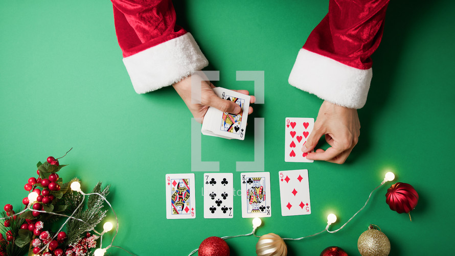 Santa Claus playing solitaire with cards 