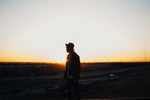 silhouette of a man in a hat at sunset 