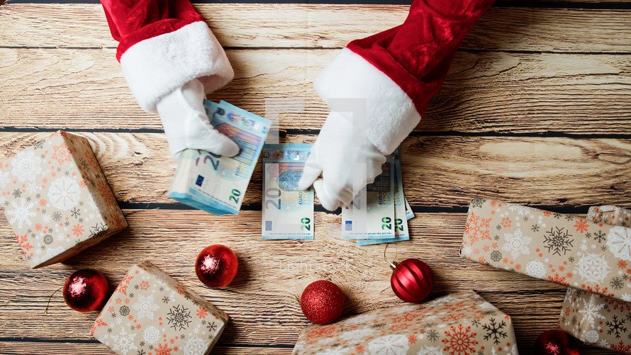 Santa Claus counting money for Christmas presents 