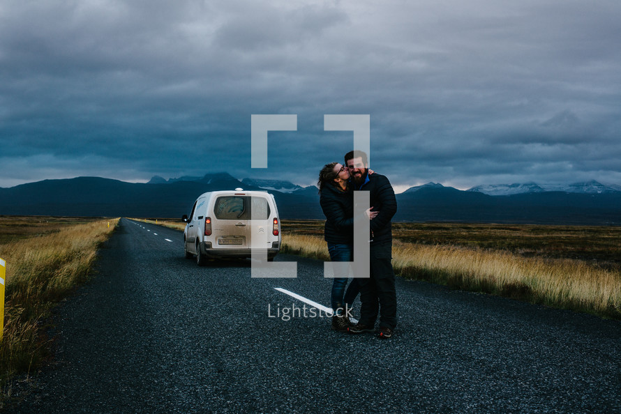 a couple kissing in the middle of a road in Iceland 