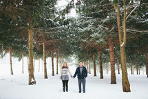 a couple holding hands in snow 