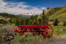 red wagon in a valley and mountain peaks 