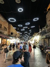 people walking through a market at night 
