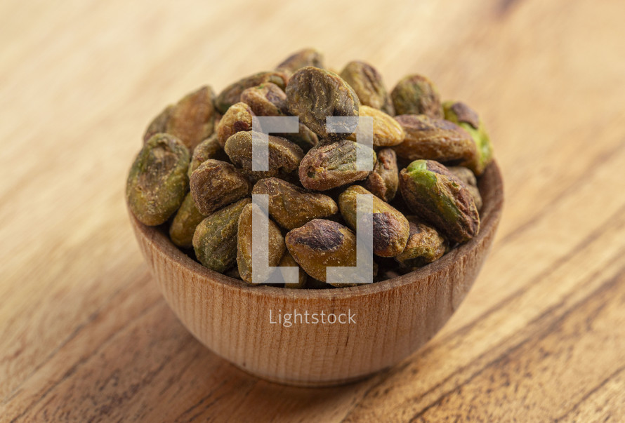 Roasted and Salted Pistachios without Shells on a Wood Table