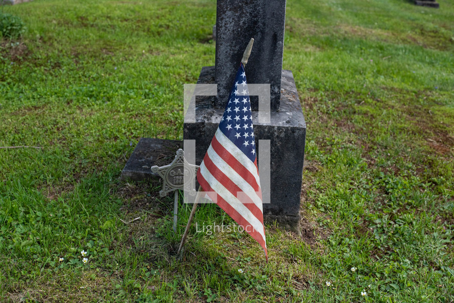 American flag next to a grave 