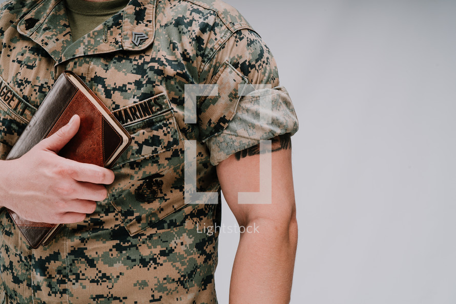 a marine holding a Bible to his chest 
