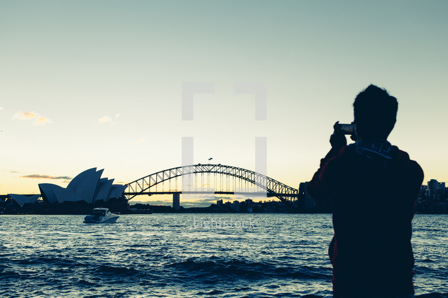 man taking a picture of Sydney Harbour Bridge