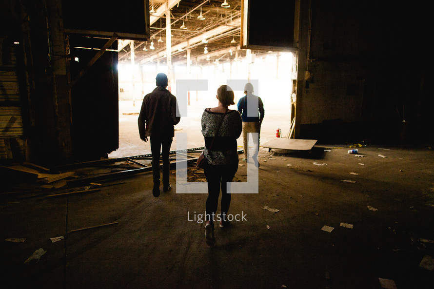 people walking through and abandoned warehouse 