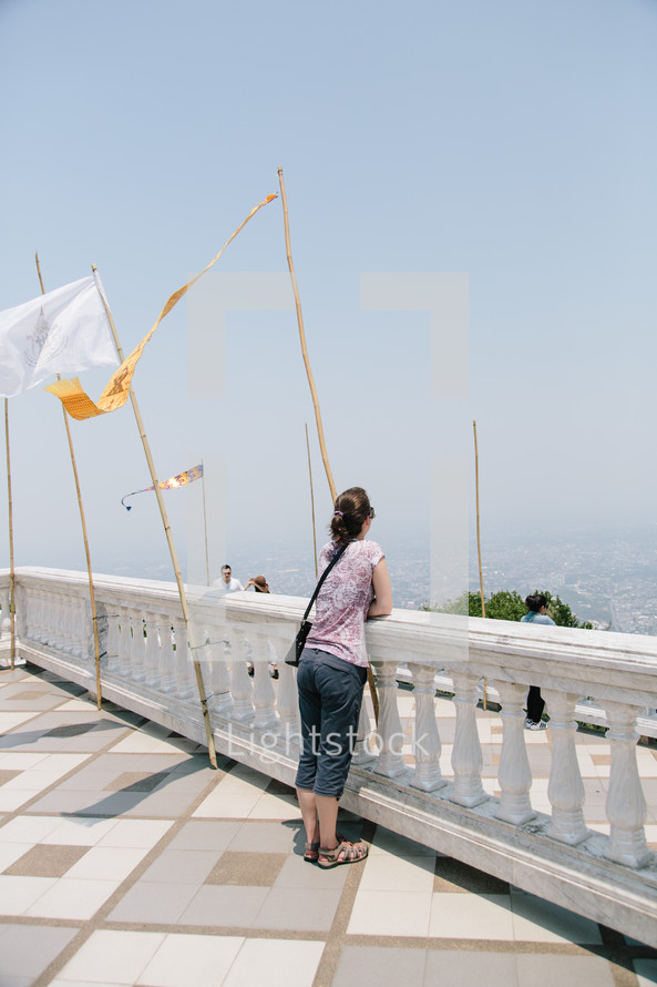 a woman taking in the view over a railing 