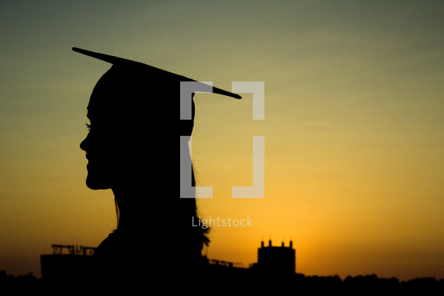 silhouette of a female graduate at sunset 