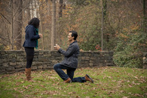 man down on one knee proposing to a woman