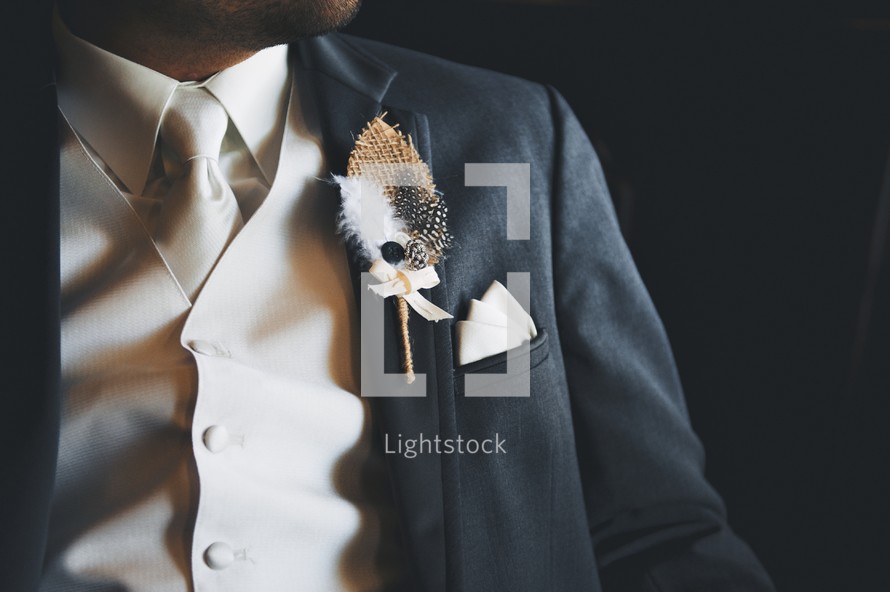 Feather boutonniere on a suit lapel.  