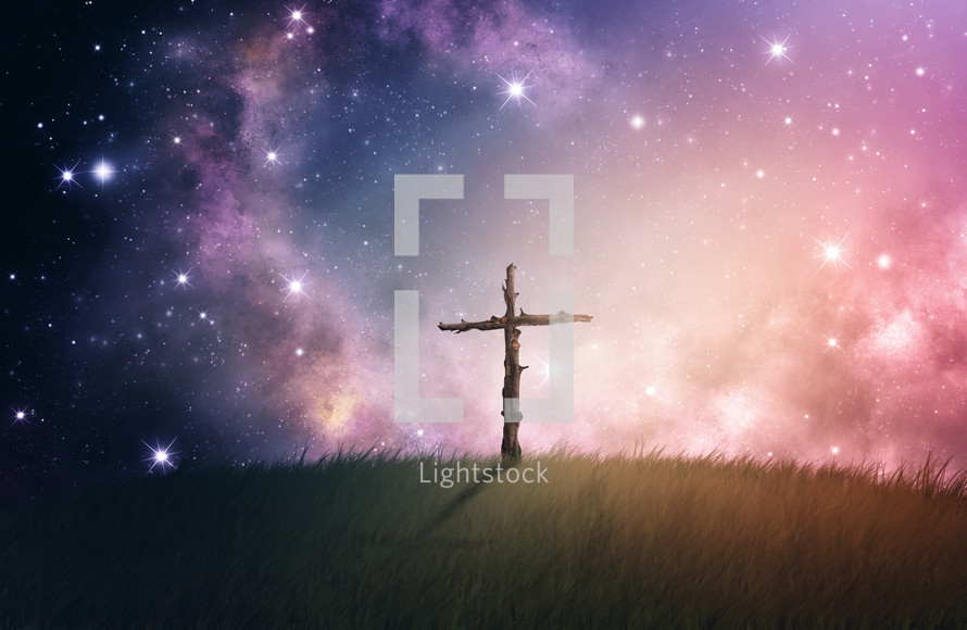Wooden cross on a hill in the starry night sky.