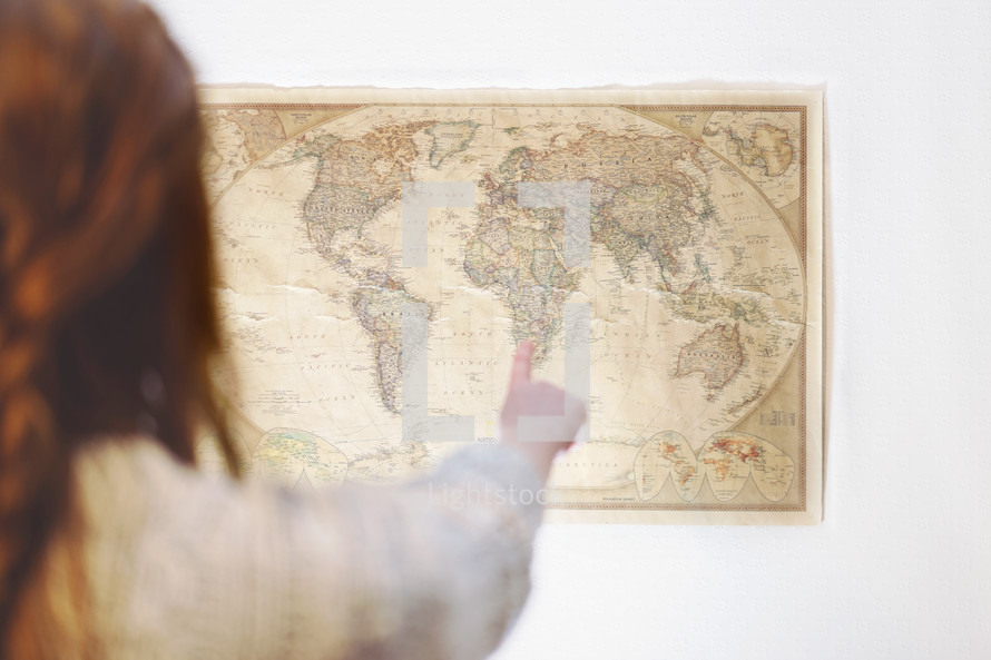woman pointing to a world map 