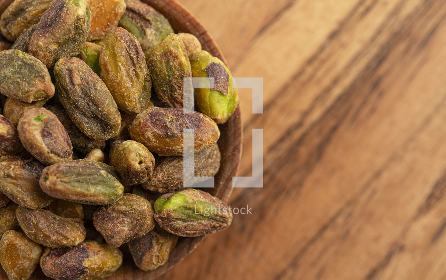 Roasted and Salted Pistachios without Shells on a Wood Table