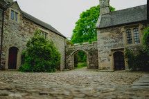 cobblestone courtyard in front of a castle 