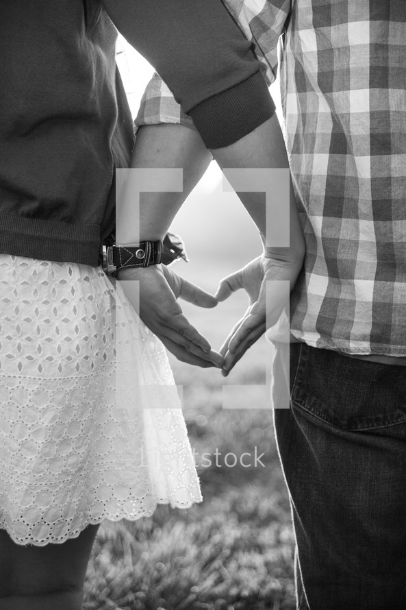 couple forming a heart with their hands 