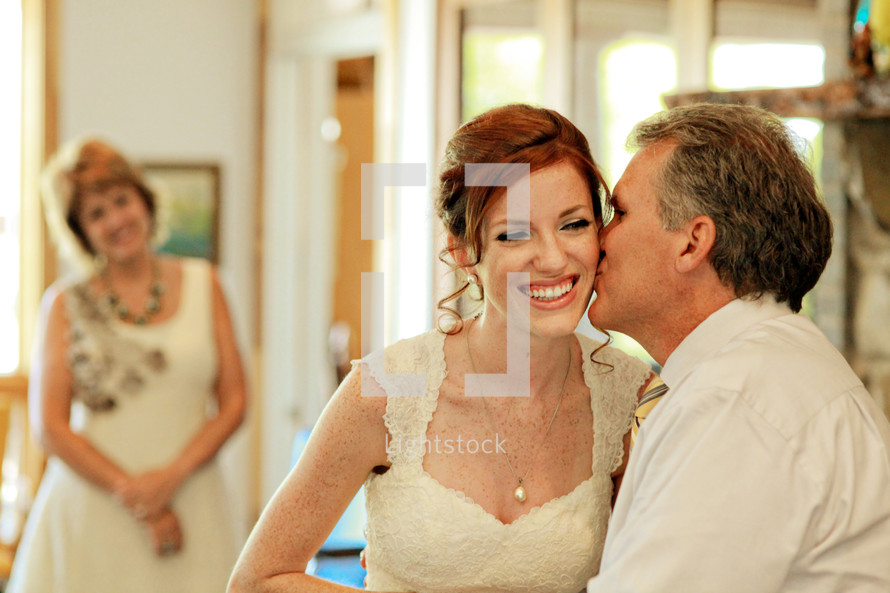 father kissing his daughter bride before a wedding