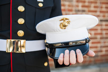 Marine holding his hat 
