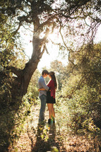 couple hugging under a tree in a forest