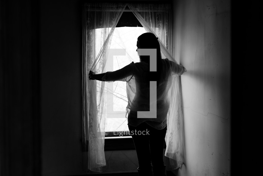 young woman looking out a window 