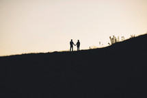 distant silhouette of a couple holding hands