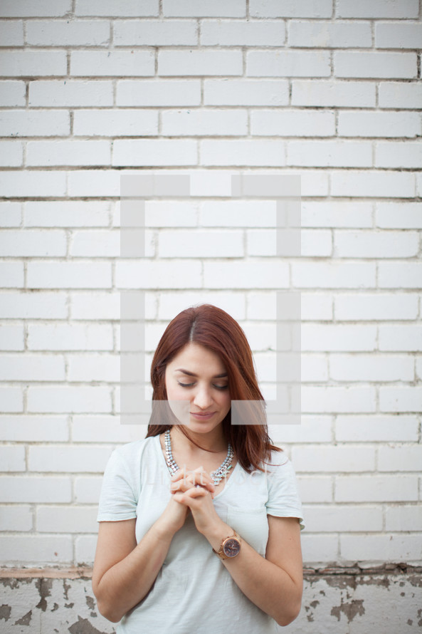 a young woman with praying hands 