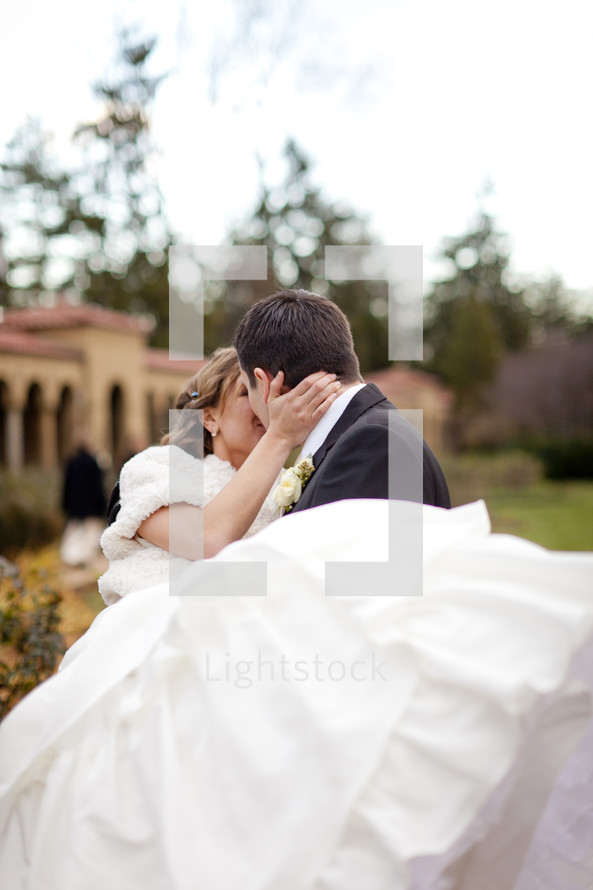 man holding and kissing his bride