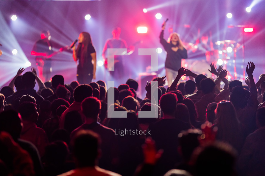 worship leaders on stage singing during a worship service 