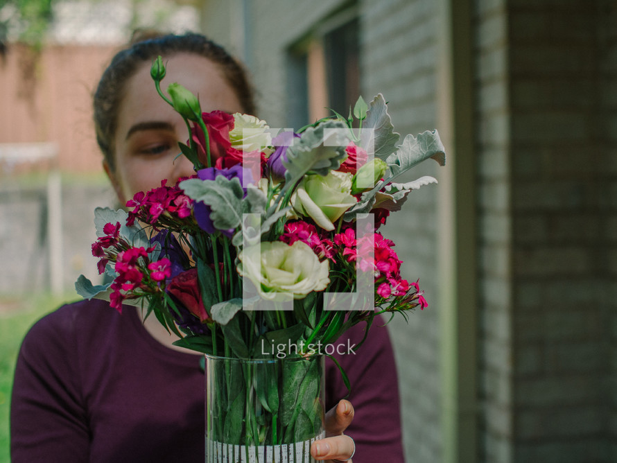 a woman holding a vase full of flowers 