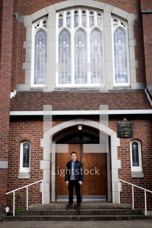 a man standing in front of church doors 