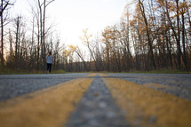 a woman walking on a road in fall 