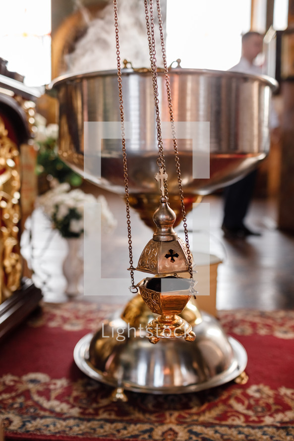 selective focus. A priest's censer hangs on an old wall in the Orthodox Church. Copper incense with burning coal inside. Service in the concept of the Orthodox Church. Adoration