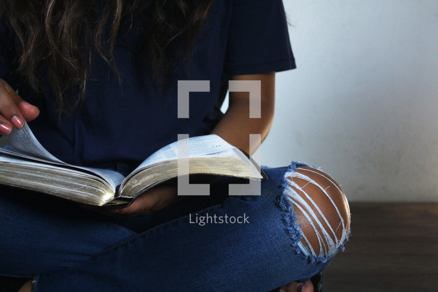 a girl reading a Bible in her lap 