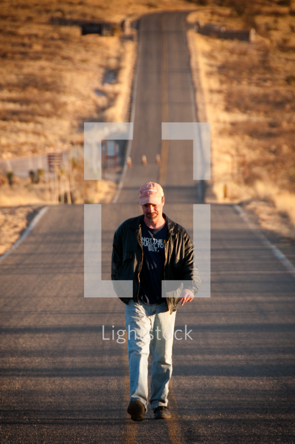 Man walking down the middle of the road.