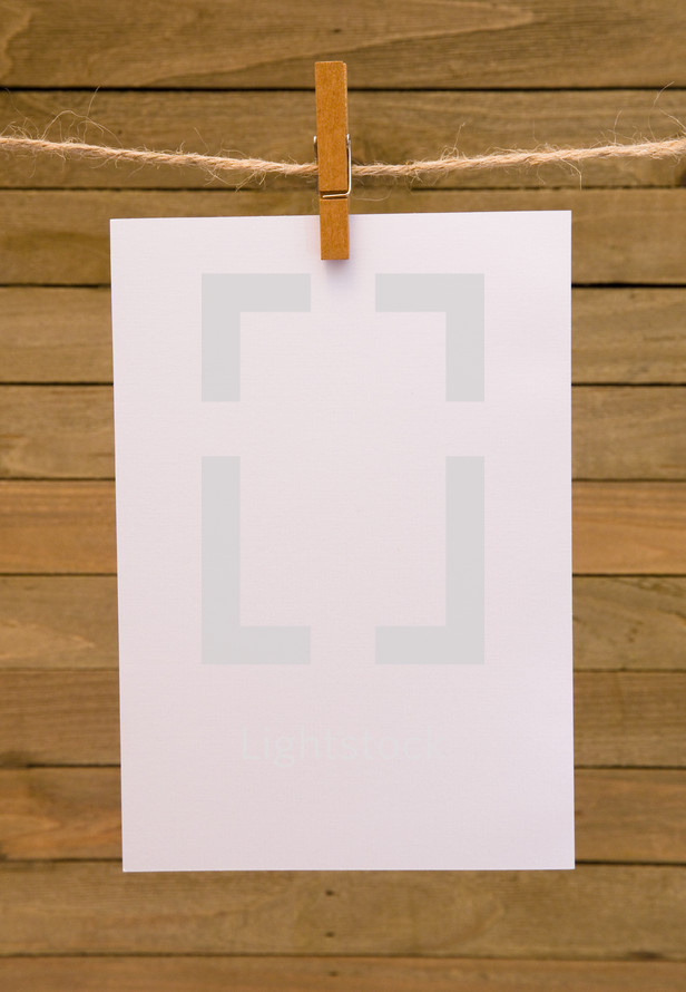 blank white paper hanging by clothespins 