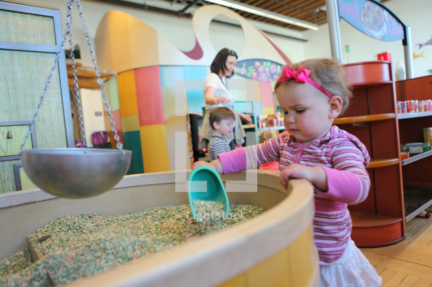 toddler girl playing at a discovery center 