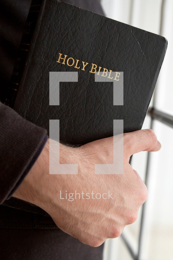 man carrying a Holy Bible