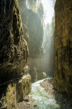 sunlight shining into a river in a canyon 